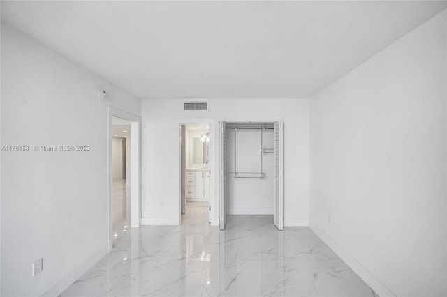 unfurnished bedroom featuring visible vents, baseboards, marble finish floor, and a closet