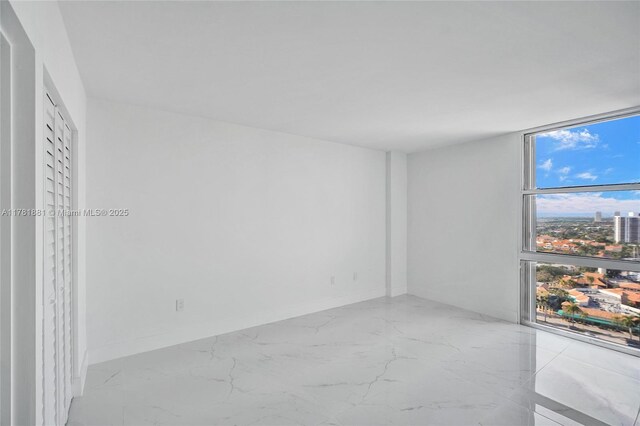 3625 N Country Club Dr Unit 2310, Aventura, FL 33180 - empty room with marble finish floors, a city view, baseboards, and expansive windows