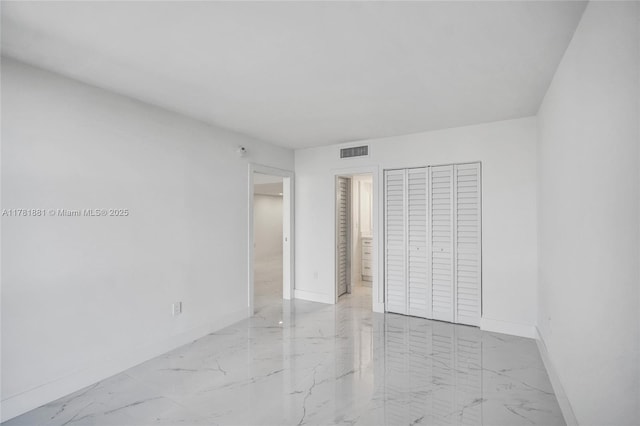 unfurnished bedroom with marble finish floor, baseboards, visible vents, and connected bathroom