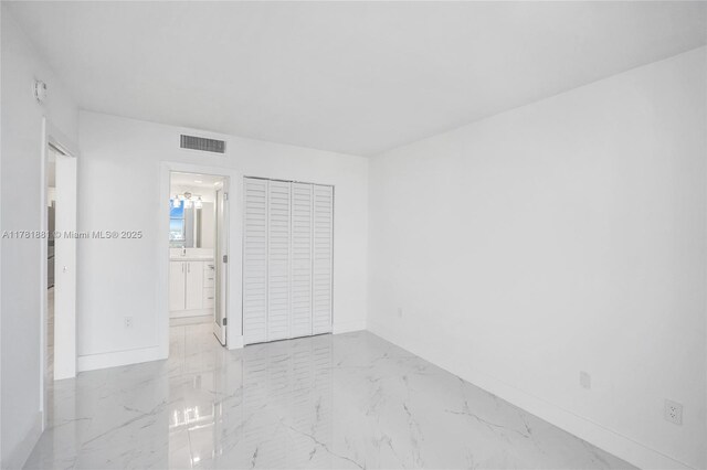 3625 N Country Club Dr Unit 2310, Aventura, FL 33180 - unfurnished bedroom with baseboards, light marble finish flooring, and connected bathroom