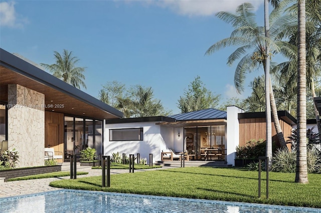 back of property featuring a yard and a standing seam roof