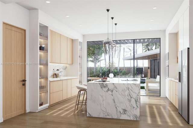 kitchen with light wood-style flooring, stainless steel fridge with ice dispenser, light brown cabinets, and modern cabinets