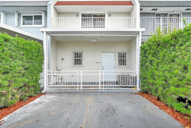 1845 W 73rd Pl Unit 1845, Hialeah, FL 33014 - doorway to property with a balcony and roof with shingles