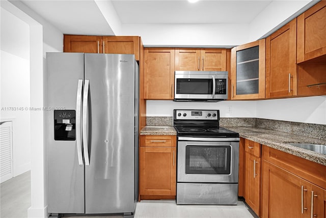 1845 W 73rd Pl Unit 1845, Hialeah, FL 33014 - kitchen featuring appliances with stainless steel finishes, brown cabinets, glass insert cabinets, and dark stone countertops
