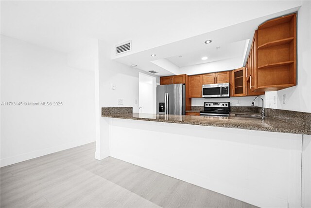 1845 W 73rd Pl Unit 1845, Hialeah, FL 33014 - kitchen with appliances with stainless steel finishes, a sink, light wood finished floors, brown cabinetry, and recessed lighting
