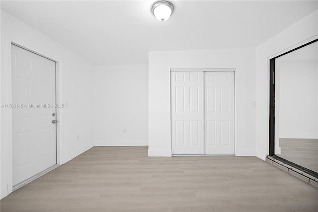 1845 W 73rd Pl Unit 1845, Hialeah, FL 33014 - unfurnished bedroom featuring light wood-style floors, baseboards, baseboard heating, and a closet