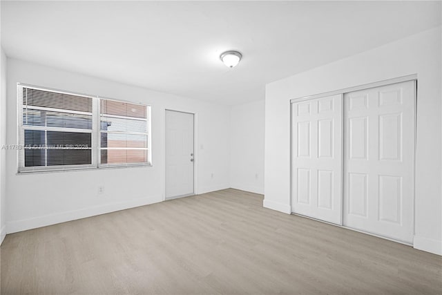 1845 W 73rd Pl Unit 1845, Hialeah, FL 33014 - unfurnished bedroom featuring wood finished floors, baseboards, and a closet