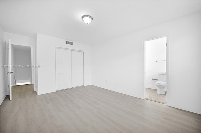 1845 W 73rd Pl Unit 1845, Hialeah, FL 33014 - unfurnished bedroom with light wood-style flooring, a closet, baseboards, and ensuite bath