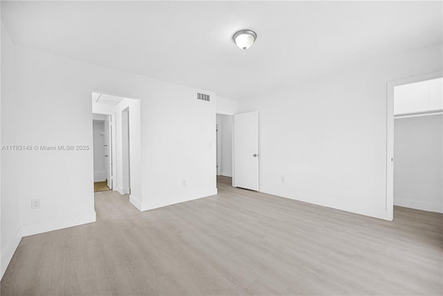 1845 W 73rd Pl Unit 1845, Hialeah, FL 33014 - unfurnished bedroom with light wood finished floors, a walk in closet, baseboards, and a closet