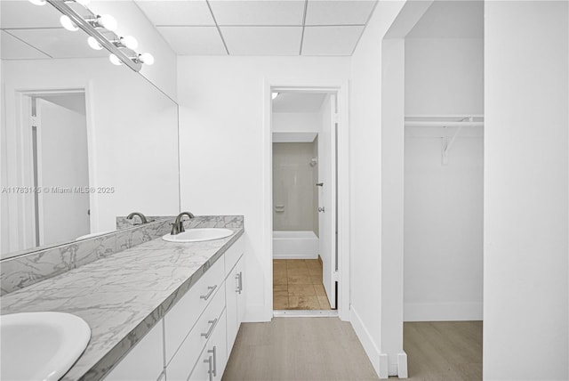 1845 W 73rd Pl Unit 1845, Hialeah, FL 33014 - bathroom featuring double vanity, a shower, a paneled ceiling, a walk in closet, and baseboards
