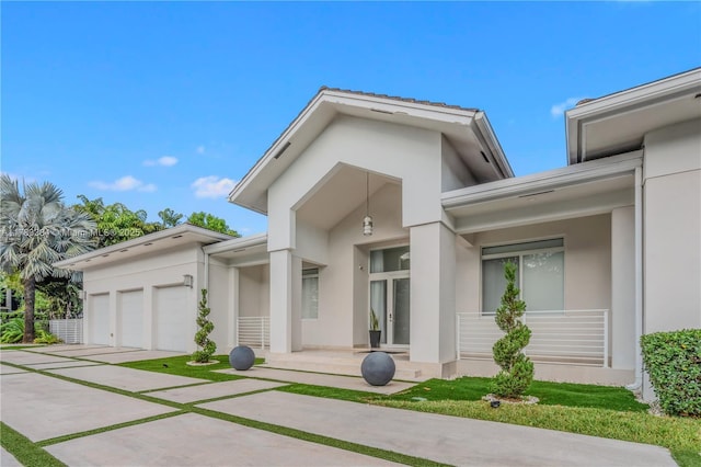 exterior space featuring an attached garage, driveway, and stucco siding