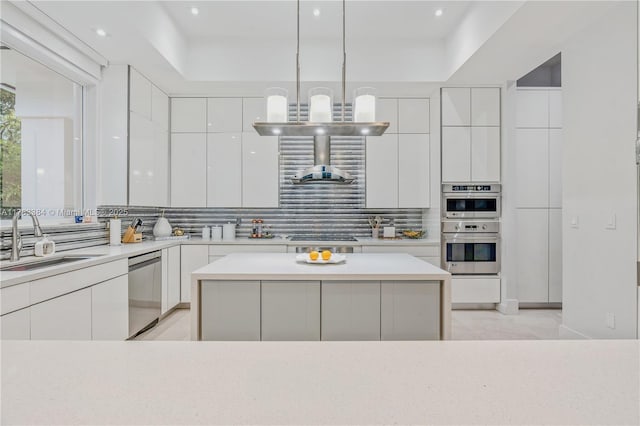 kitchen with modern cabinets, tasteful backsplash, white cabinetry, a sink, and stainless steel appliances