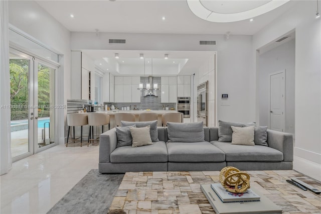 living area with visible vents, recessed lighting, and a tray ceiling