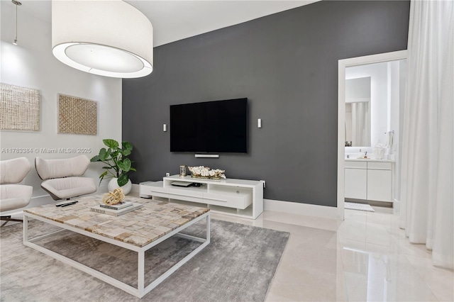 living area with light tile patterned floors and baseboards