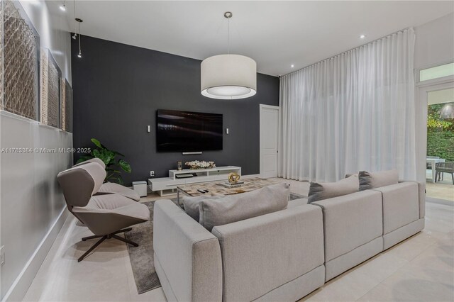 living area featuring tile patterned floors, recessed lighting, and a towering ceiling