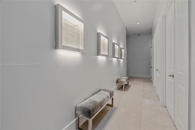corridor with light tile patterned floors and baseboards