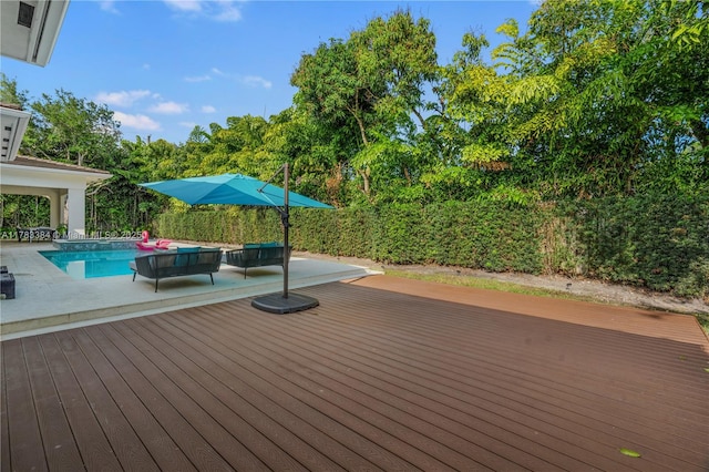 deck featuring a patio area and a fenced in pool