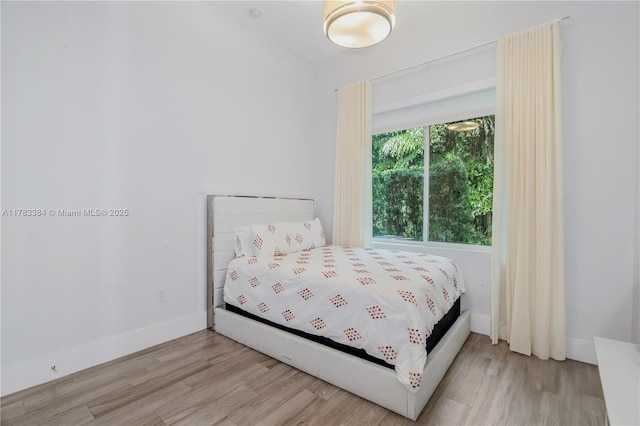 bedroom featuring baseboards and wood finished floors