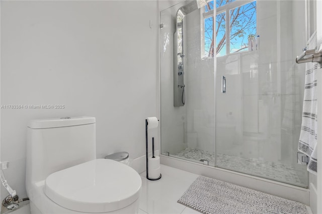 bathroom featuring a shower stall, tile patterned floors, and toilet