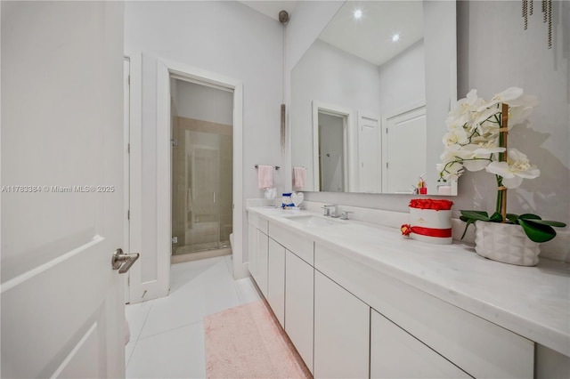full bathroom featuring a stall shower, vanity, and tile patterned flooring