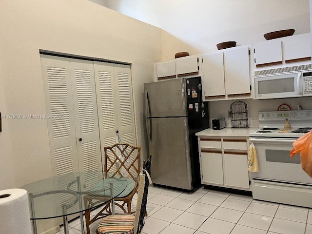 kitchen with white appliances, white cabinetry, light countertops, and light tile patterned floors