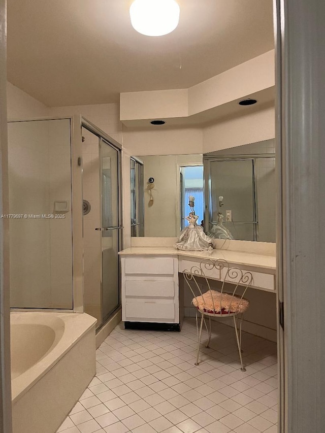 bathroom with a shower stall, tile patterned floors, a garden tub, and vanity