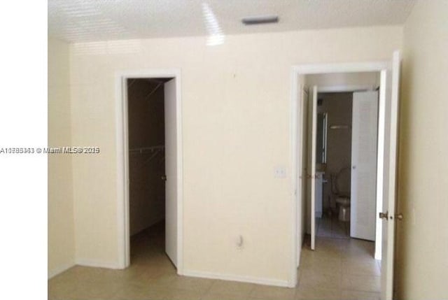 16465 NE 22nd Ave Unit 205, North Miami Beach, FL 33160 - unfurnished bedroom featuring a walk in closet, baseboards, and visible vents