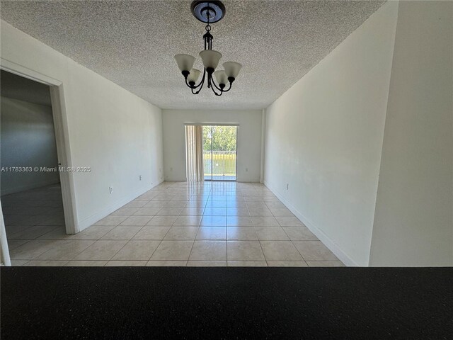 16465 NE 22nd Ave Unit 205, North Miami Beach, FL 33160 - unfurnished room with a chandelier, light tile patterned floors, and a textured ceiling