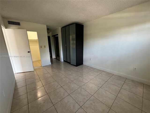 16465 NE 22nd Ave Unit 205, North Miami Beach, FL 33160 - unfurnished room featuring a textured ceiling, light tile patterned flooring, baseboards, and visible vents