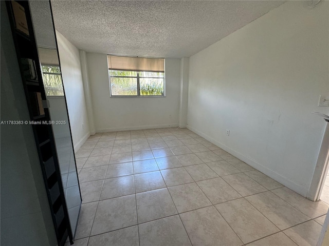16465 NE 22nd Ave Unit 205, North Miami Beach, FL 33160 - unfurnished room with a textured ceiling, light tile patterned floors, and baseboards