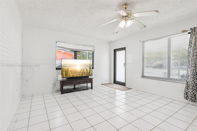 empty room with baseboards, a textured ceiling, and a ceiling fan