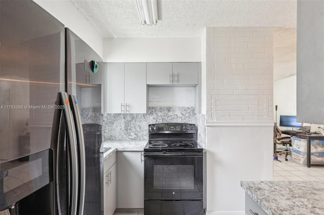 kitchen with freestanding refrigerator, tasteful backsplash, electric range, a textured ceiling, and gray cabinetry
