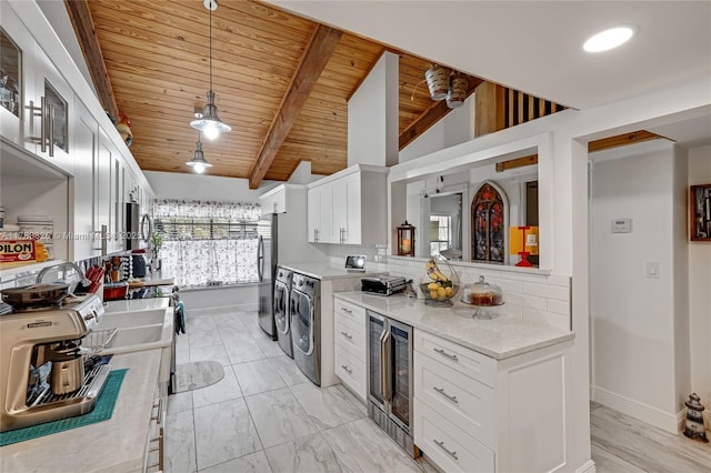 kitchen featuring white cabinetry, beverage cooler, decorative backsplash, washer and dryer, and wood ceiling