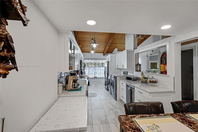 kitchen featuring white cabinetry, freestanding refrigerator, beam ceiling, and wood ceiling