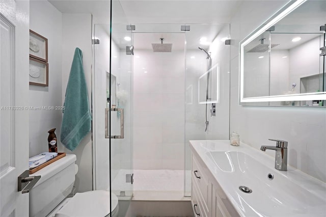 bathroom featuring toilet, a stall shower, vanity, and visible vents