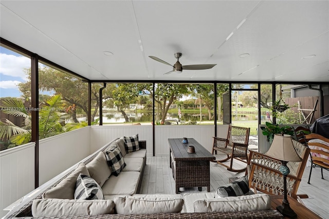 sunroom / solarium with a water view, a wealth of natural light, outdoor lounge area, and ceiling fan