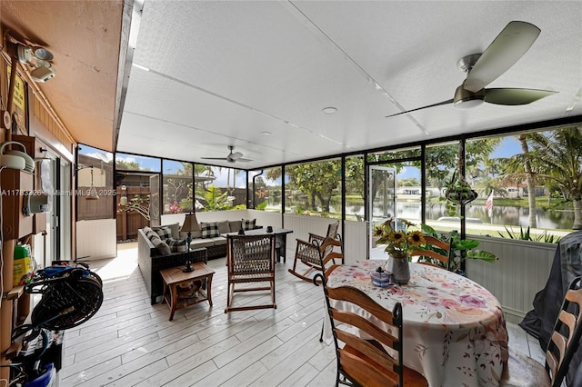 sunroom / solarium featuring an outdoor living space, outdoor dining space, and ceiling fan
