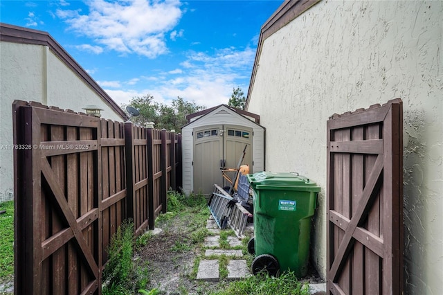 exterior space with a storage shed, a fenced backyard, an outdoor structure, and stucco siding