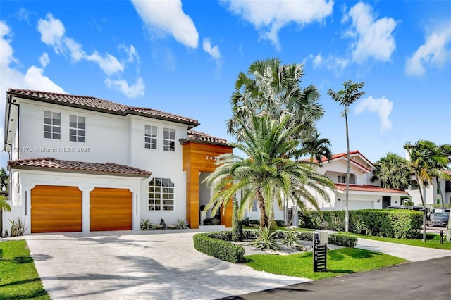 3408 NE 169th St, North Miami Beach, FL 33160 - mediterranean / spanish-style house with a tiled roof, an attached garage, driveway, and stucco siding