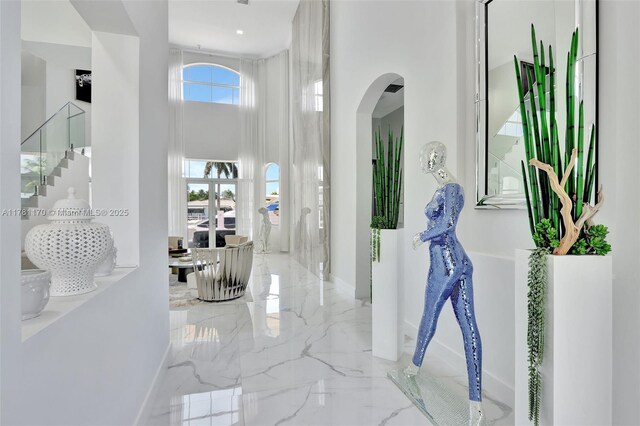 3408 NE 169th St, North Miami Beach, FL 33160 - corridor with baseboards, arched walkways, a high ceiling, stairway, and marble finish floor