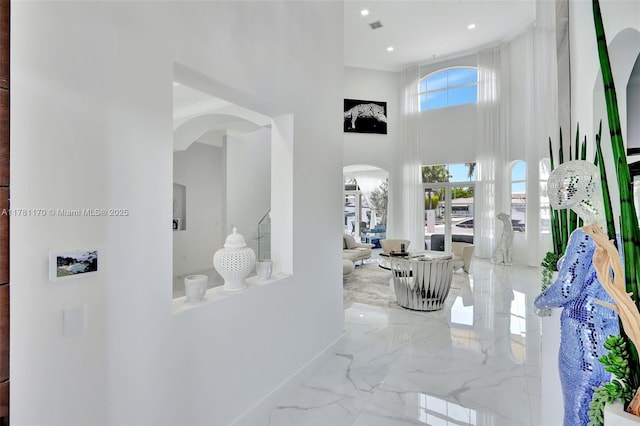 3408 NE 169th St, North Miami Beach, FL 33160 - hall featuring arched walkways, visible vents, a high ceiling, marble finish floor, and baseboards