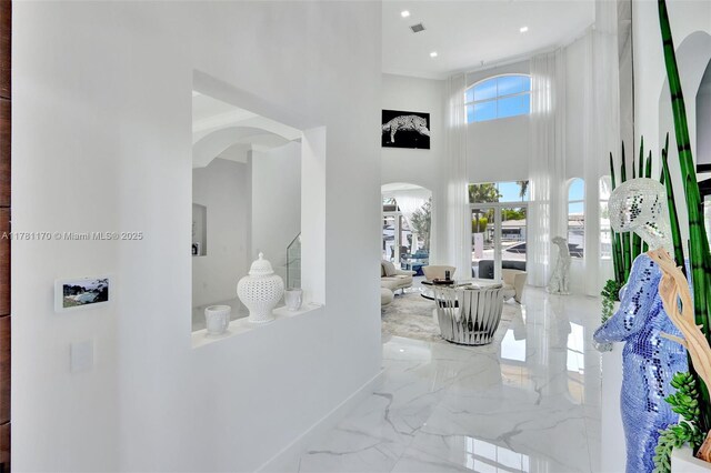 3408 NE 169th St, North Miami Beach, FL 33160 - hall featuring arched walkways, visible vents, a high ceiling, marble finish floor, and baseboards