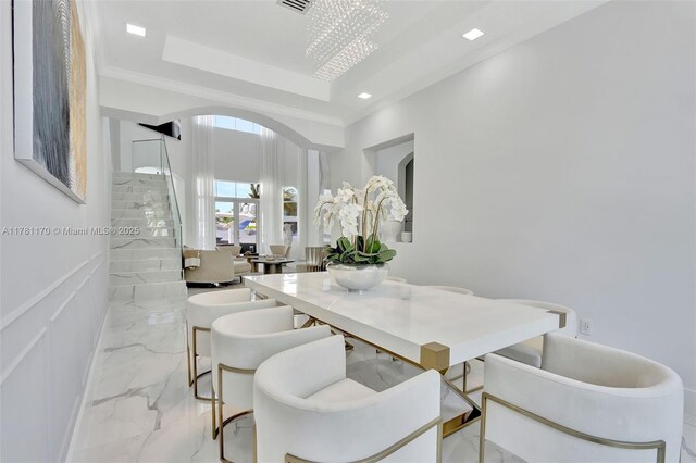 3408 NE 169th St, North Miami Beach, FL 33160 - dining area featuring a raised ceiling, arched walkways, marble finish floor, and stairs