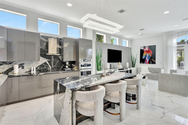 3408 NE 169th St, North Miami Beach, FL 33160 - kitchen with gray cabinets, wall chimney range hood, visible vents, modern cabinets, and a sink