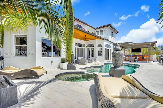 3408 NE 169th St, North Miami Beach, FL 33160 - back of house featuring a patio, a pool with connected hot tub, stucco siding, and a balcony