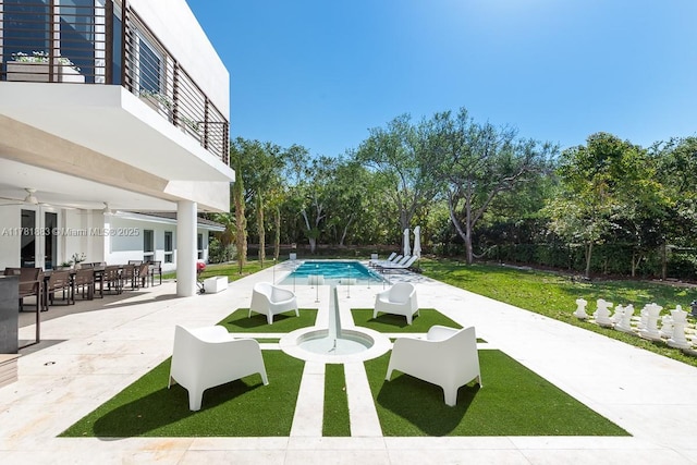 6295 SW 126th St, Pinecrest, FL 33156 - view of green lawn featuring a patio area, an outdoor pool, a balcony, outdoor dining space, and view of scattered trees