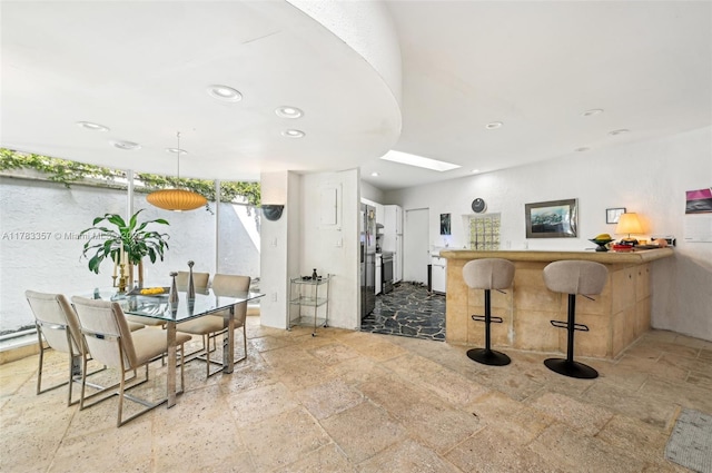 3200 Morris Ln, Miami, FL 33133 - interior space with recessed lighting, a peninsula, a breakfast bar area, and stone tile flooring