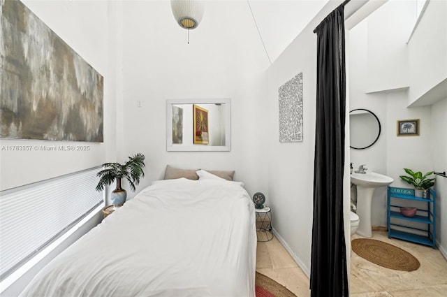 3200 Morris Ln, Miami, FL 33133 - bedroom featuring light tile patterned floors, connected bathroom, a high ceiling, a sink, and baseboards