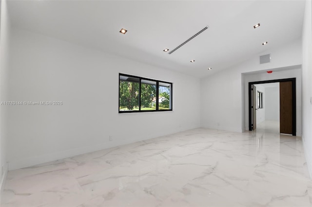 spare room with marble finish floor, lofted ceiling, and visible vents