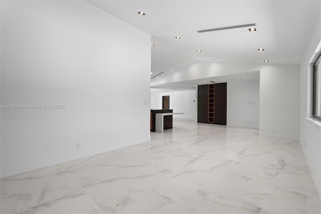 unfurnished room with marble finish floor, recessed lighting, and vaulted ceiling